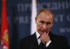 Deal Talk Masks Survival Fight Vladimir Putin at a podium during a press event