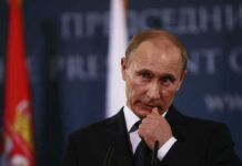 Deal Talk Masks Survival Fight Vladimir Putin at a podium during a press event