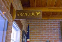 Jury Stalls After Explosive Cash Evidence Grand jury sign in a brick-walled hallway