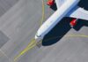 Airplane taxiing on airport tarmac from above