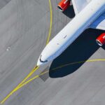 Airplane taxiing on airport tarmac from above