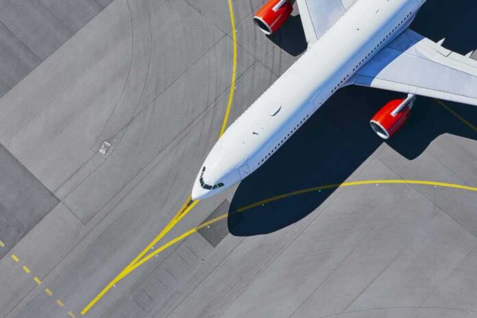 shutterstock_1189545343 Airplane taxiing on airport tarmac from above