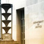 Department of Justice building exterior with sign and metal sculpture
