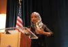 Ilhan Omar speaking at a podium with a microphone