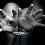 Hands bound with rope in black and white