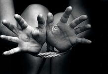 Hands bound with rope in black and white