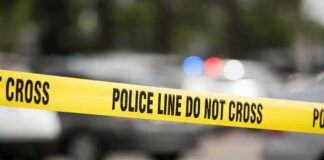 Yellow police line tape at a blurred street scene