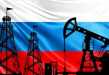 Silhouettes of oil rigs against a tricolor flag background