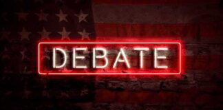Neon sign reading debate on a brick wall
