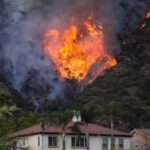 Wildfire burning on a hillside near homes
