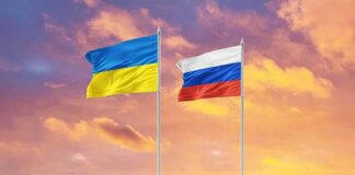 Ukrainian and Russian flags on poles at sunset