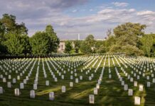 Outrage: Vets’ Funds Drift Away Rows of white headstones in a cemetery under a partly cloudy sky