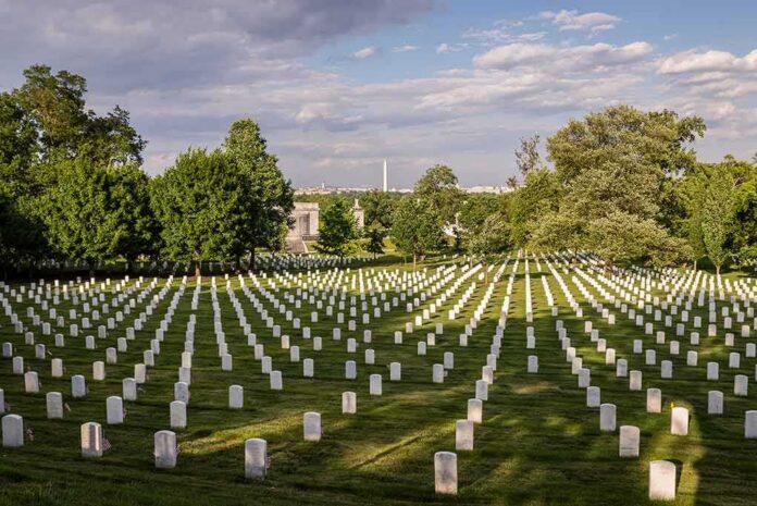 shutterstock_295252223 Rows of white headstones in a cemetery under a partly cloudy sky