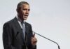 Past Blast Haunts Obama Rally Plans Rob Nabors speaking at a podium with microphones