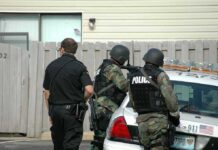 Oregon School Shooting Ends With Suspect Dead police officers in tactical gear beside patrol car